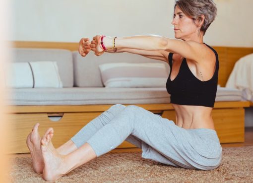 Elderly woman in a yoga pose indoors, embracing healthy lifestyle and wellness.